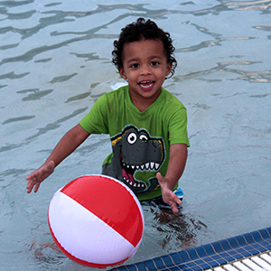 Boy with Beach Ball at Family Pool Party
