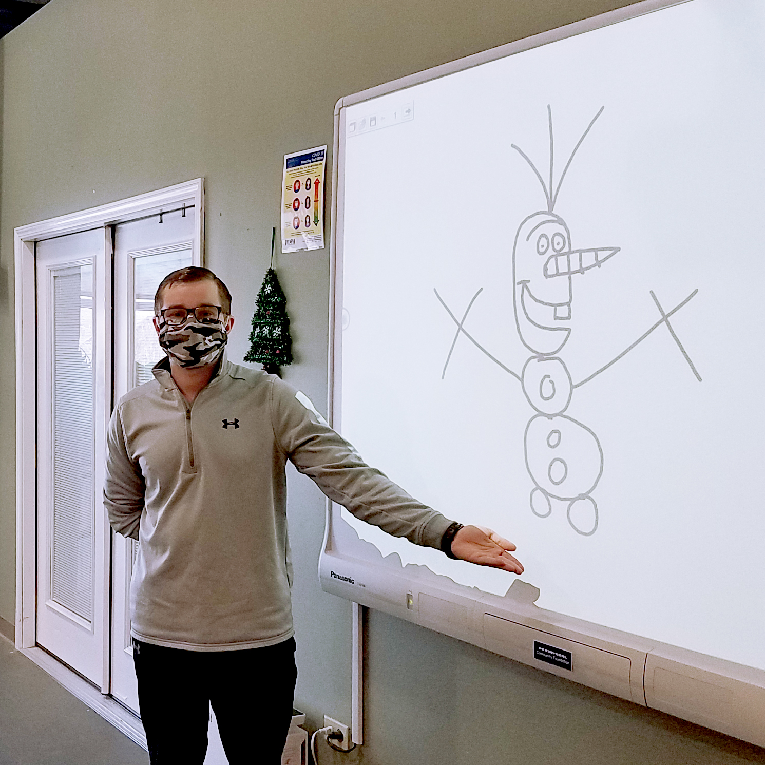 A photo of Mark, March 2022's SEASPAR Spotlight standing next to a drawing of Olaf.